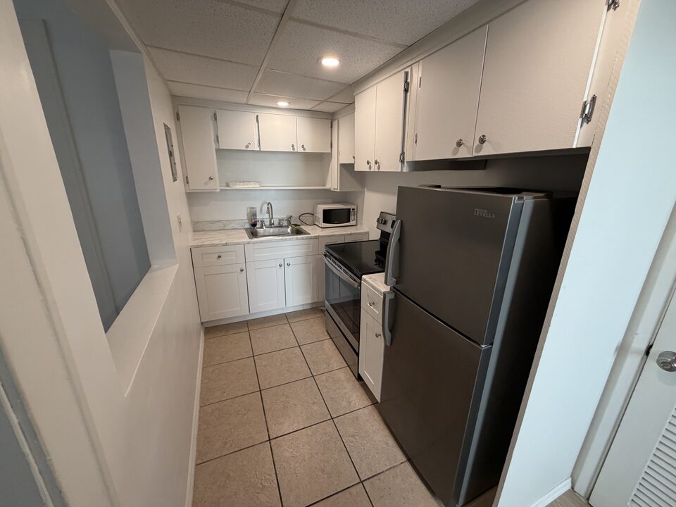 Galley kitchen with tile flooring and stainless steel appliances