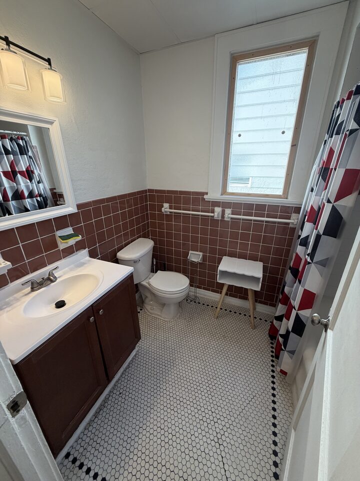 Bathroom with vanity, mirror and tiled walls