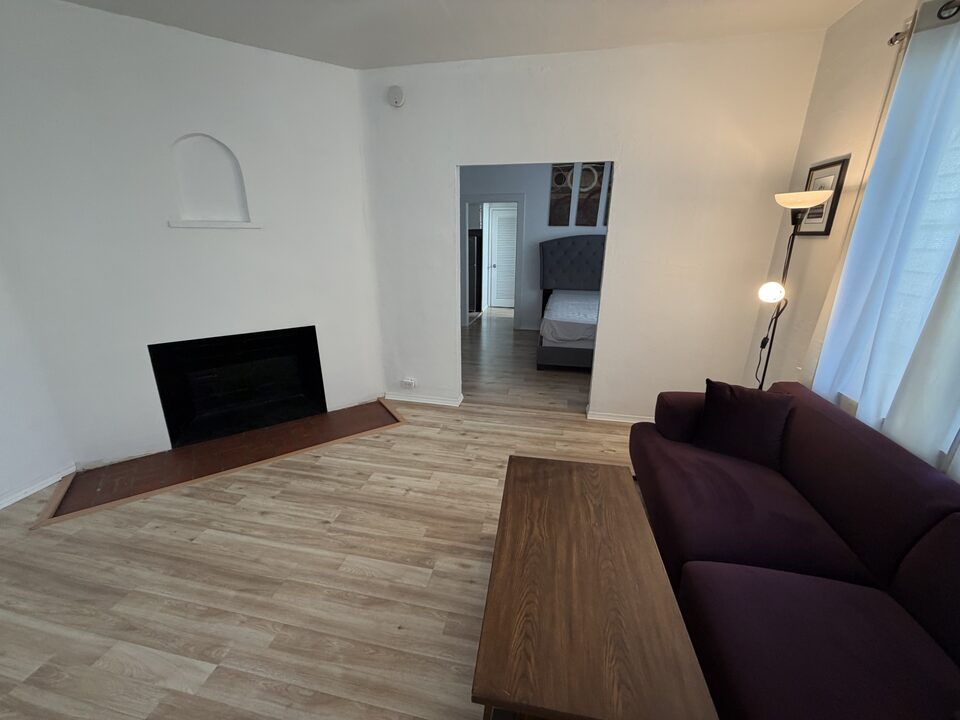 Living room with a decorative fireplace and wood-look plank flooring