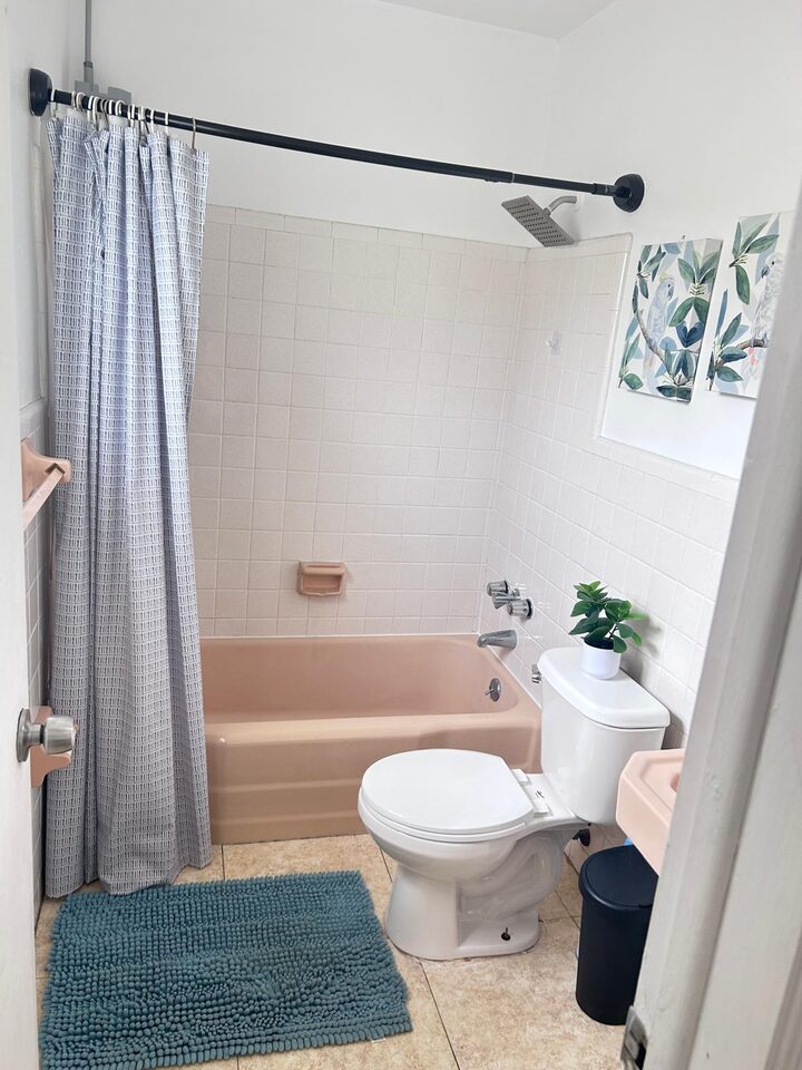 Bathroom with tiled walls, a tub and a shower curtain