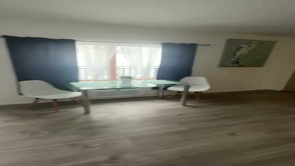 Dining area with a glass table and two chairs beside a window