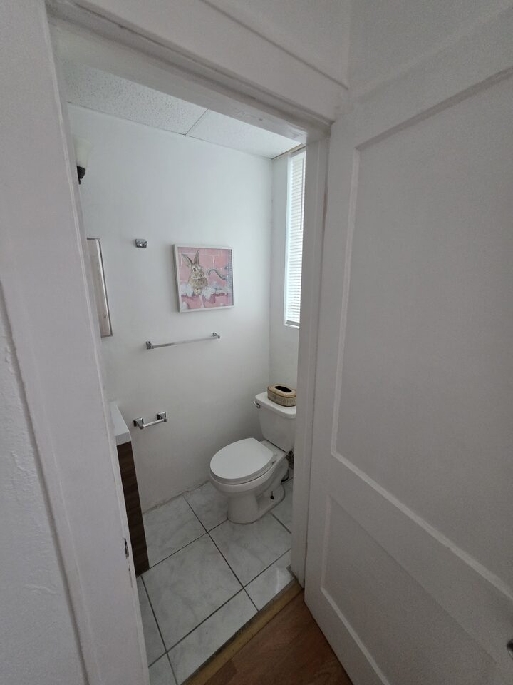 Bathroom with a toilet, a vanity and a window with blinds