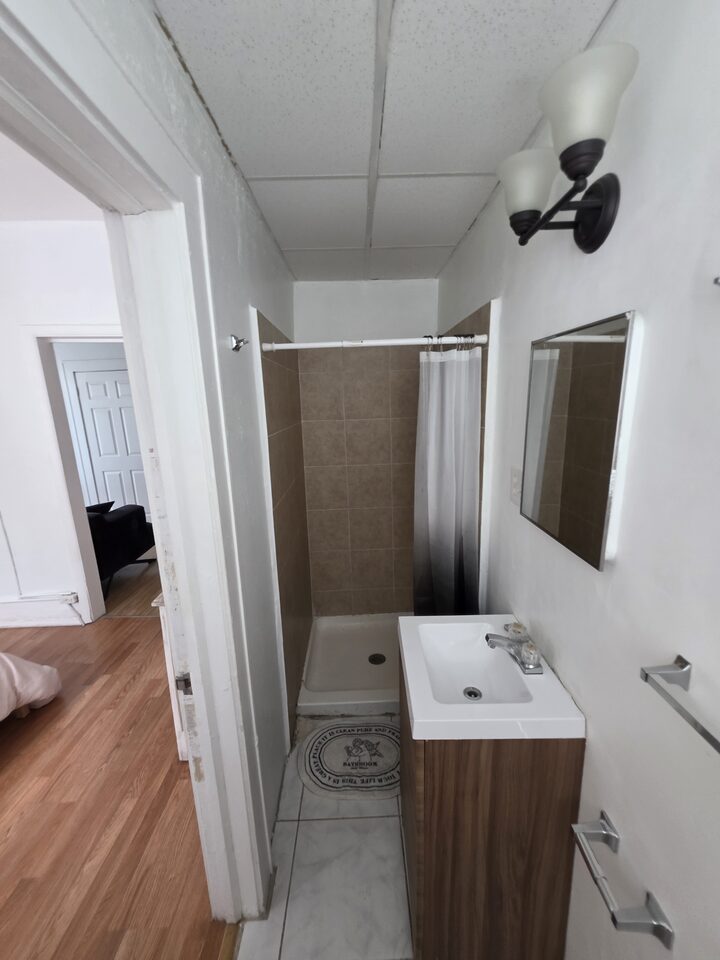 Bathroom with a walk-in shower, a tiled surround and a vanity with a mirror