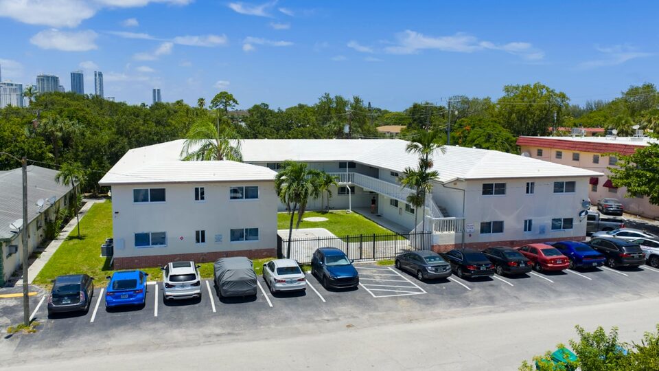 Aerial view of 811 SE 16th Street, a two-story white apartment building with tile roof and off-street parking