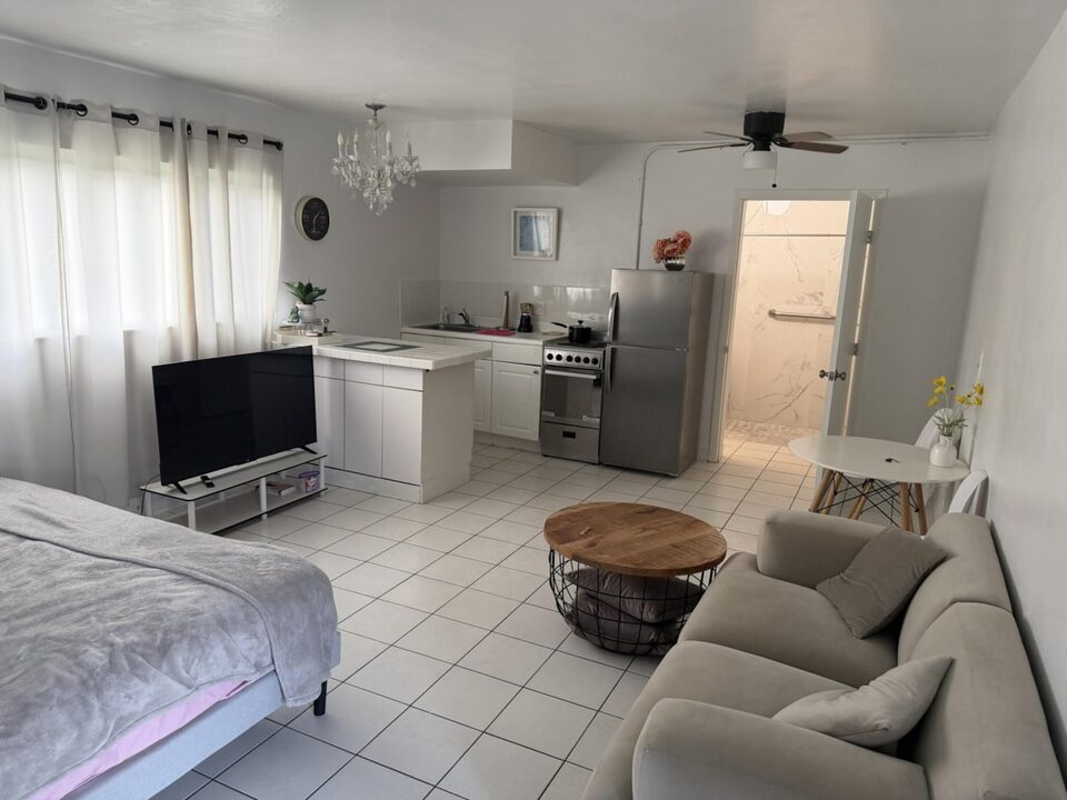 Open studio apartment with white tile floors and full kitchen