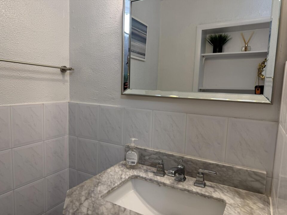 Bathroom vanity with granite countertop and framed mirror