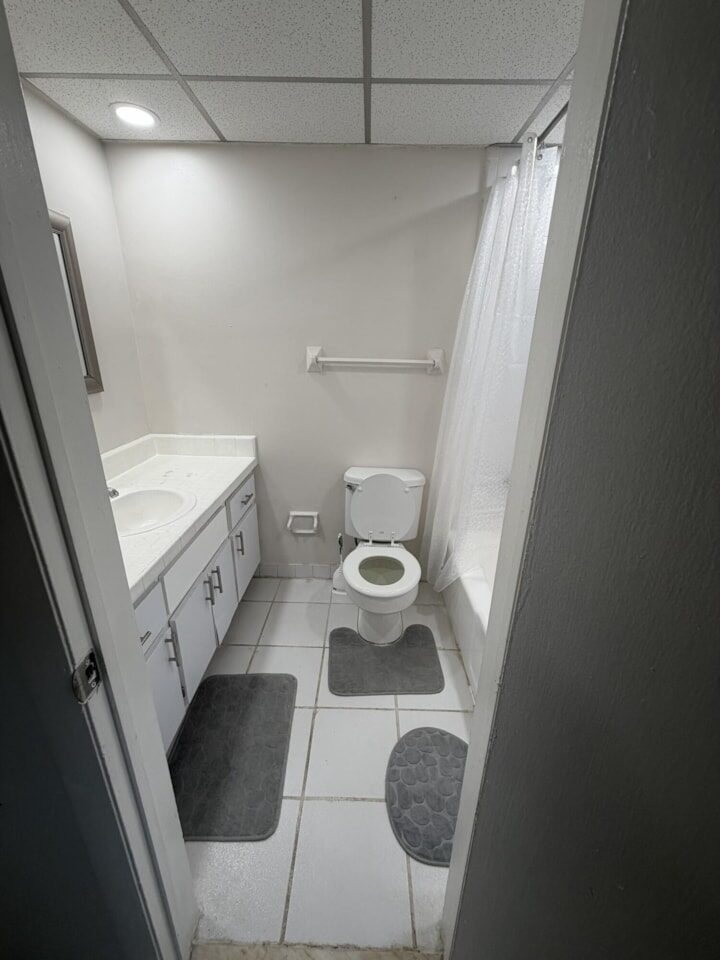 Bathroom with a vanity, toilet and tub behind a shower curtain