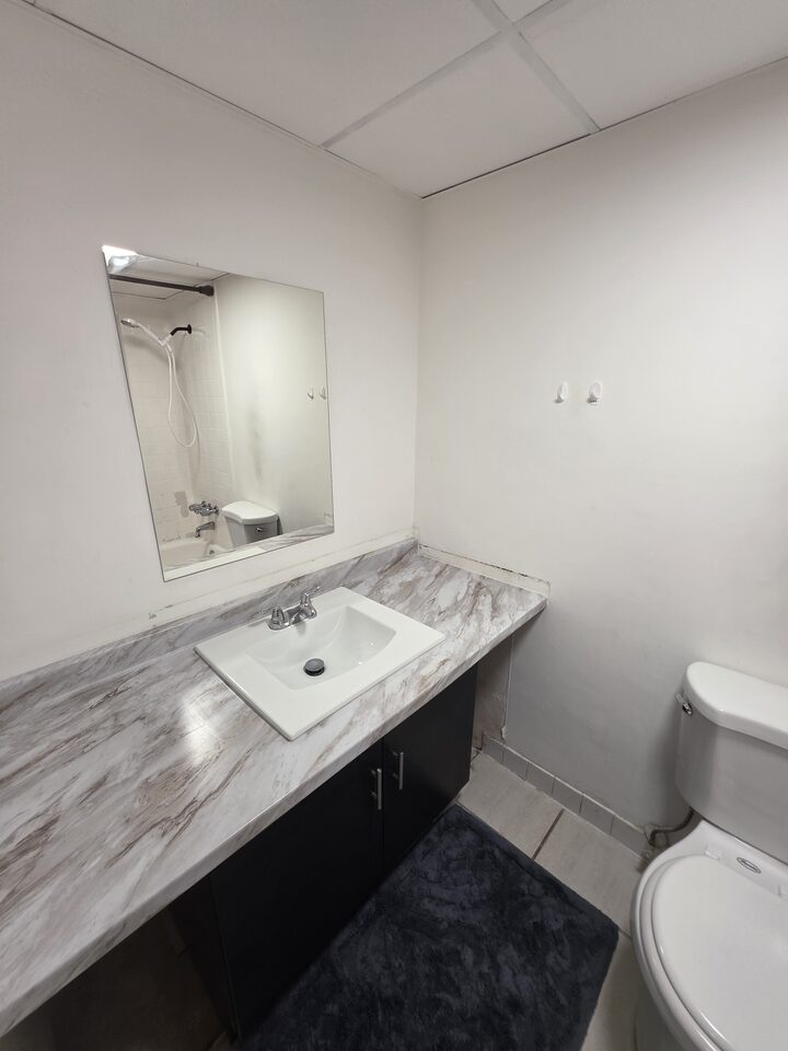 Bathroom vanity with a marble-look countertop and a mirror