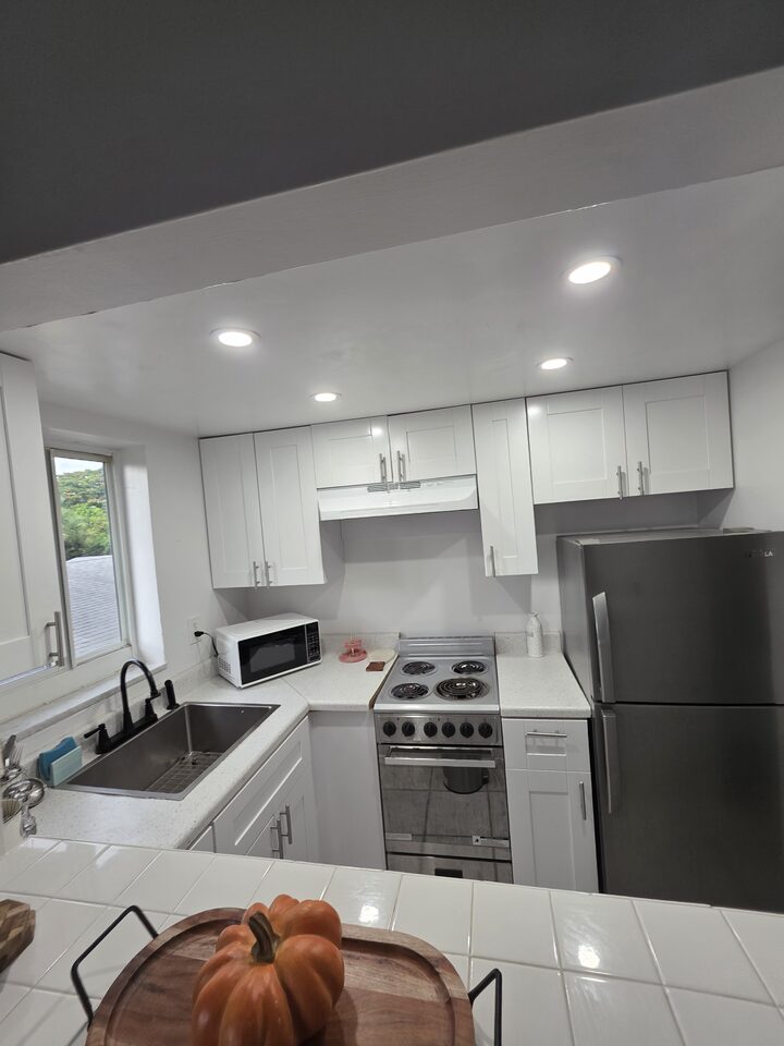 Kitchen with white shaker cabinets, recessed lighting, a stainless steel refrigerator, an electric range and a microwave
