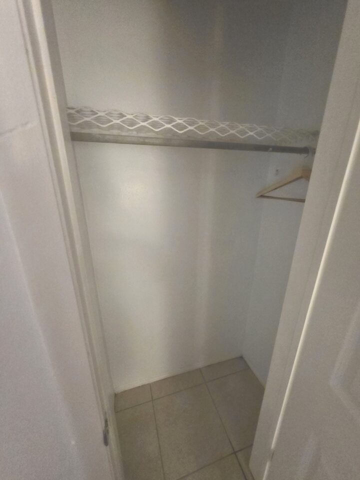 Closet with a wire shelf, a hanging rail and a wooden hanger