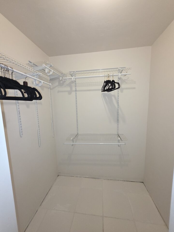 Walk-in closet with wire shelving and two hanging rails