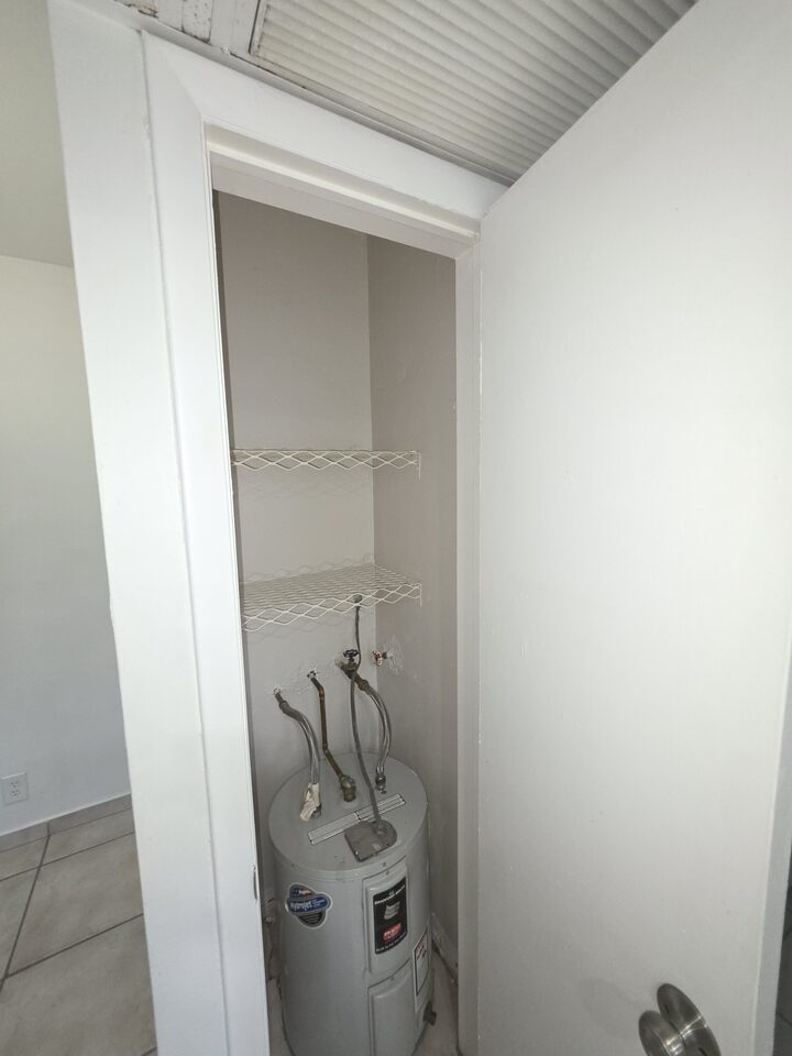 Utility closet housing the water heater, with wire shelving above