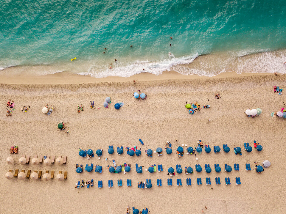A sandy beach and turquoise shallows seen from directly above