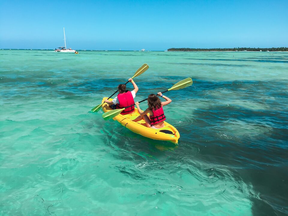 Two people kayaking on calm turquoise water