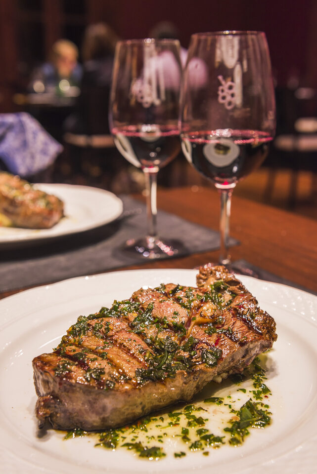A steak served with a glass of red wine